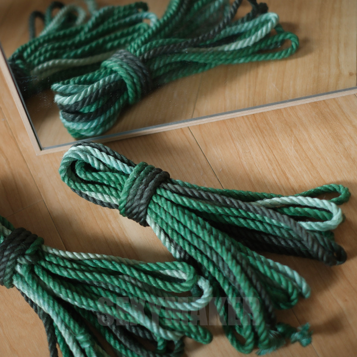 Close-up of premium treated 6mm jute Shibari rope in a dark to light green gradient for authentic Kinbaku and rope bondage by Sexy Maker.