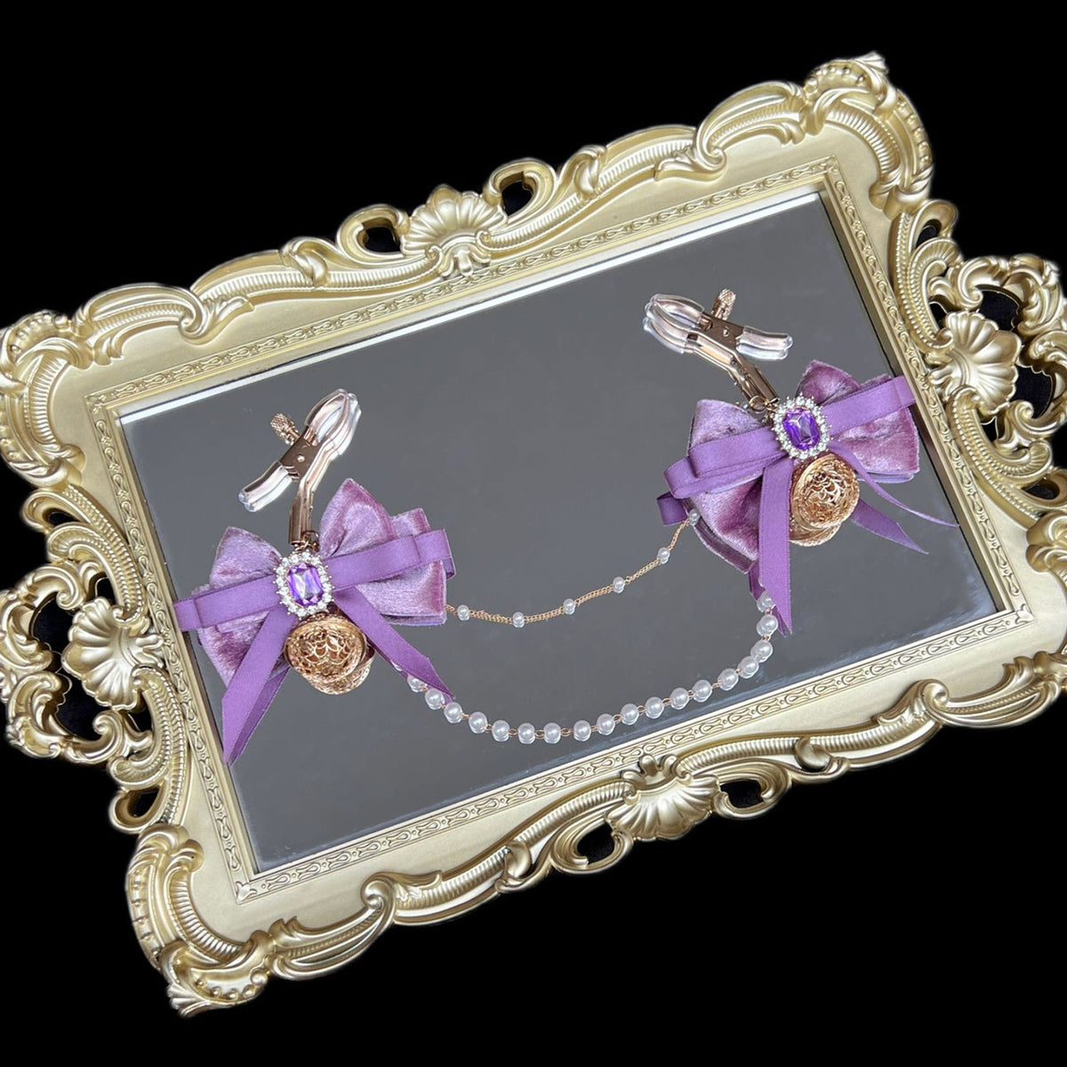 Close-up of adjustable purple ribbon nipple clamps with connecting chain and sparkling stones, beginner-friendly romantic BDSM jewelry by Sexy Maker.