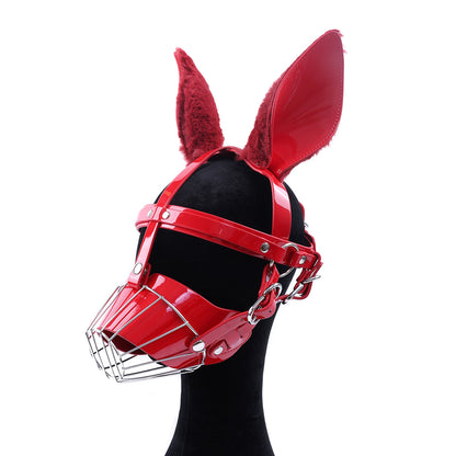 Close-up of glossy wet-look red human pup metal cage muzzle mask featuring feral fluffy faux fur ears and silver hardware for intense pet play by Sexy Maker.