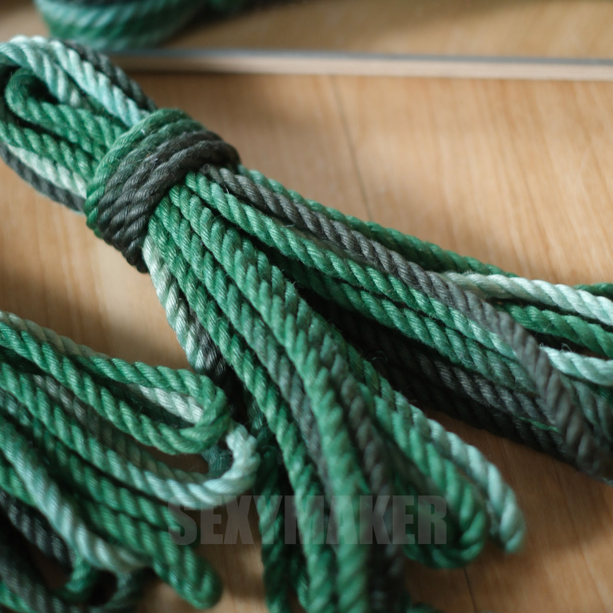 Close-up of premium treated 6mm jute Shibari rope in a dark to light green gradient for authentic Kinbaku and rope bondage by Sexy Maker.