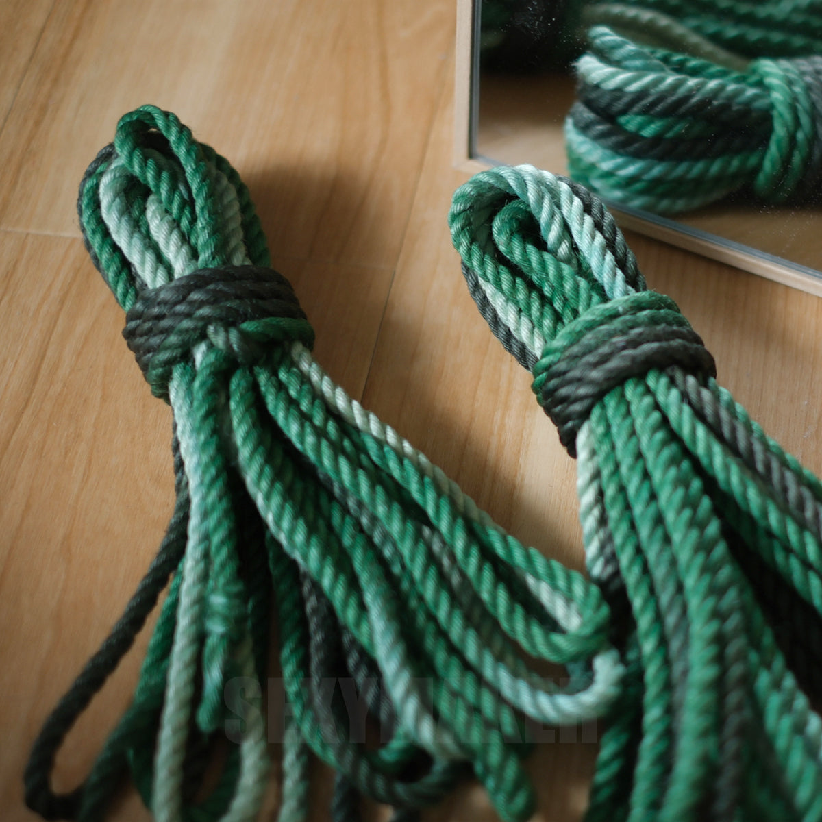 Close-up of premium treated 6mm jute Shibari rope in a dark to light green gradient for authentic Kinbaku and rope bondage by Sexy Maker.