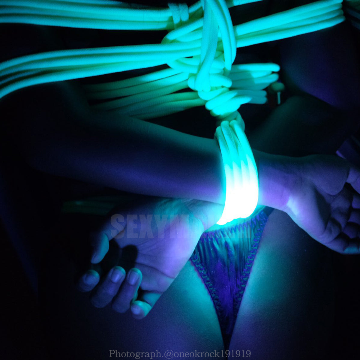 Close-up of neon green UV reactive Shibari bondage rope glowing brightly under blacklight for sensory rope play by Sexy Maker.