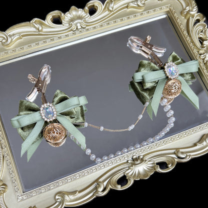 Close-up of adjustable green ribbon nipple clamps with connecting chain and sparkling stones, beginner-friendly romantic BDSM jewelry by Sexy Maker.