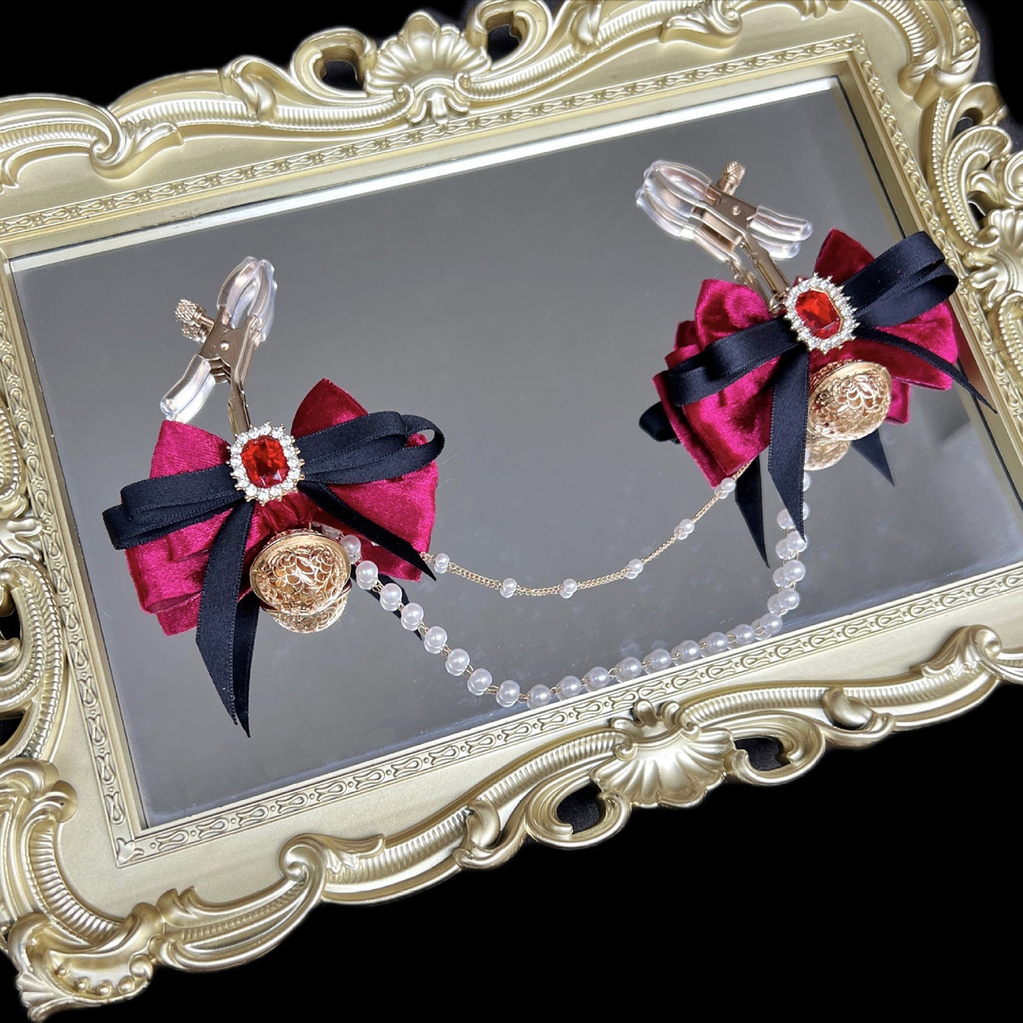 Close-up of adjustable wine red ribbon nipple clamps with connecting chain and sparkling stones, beginner-friendly romantic BDSM jewelry by Sexy Maker.