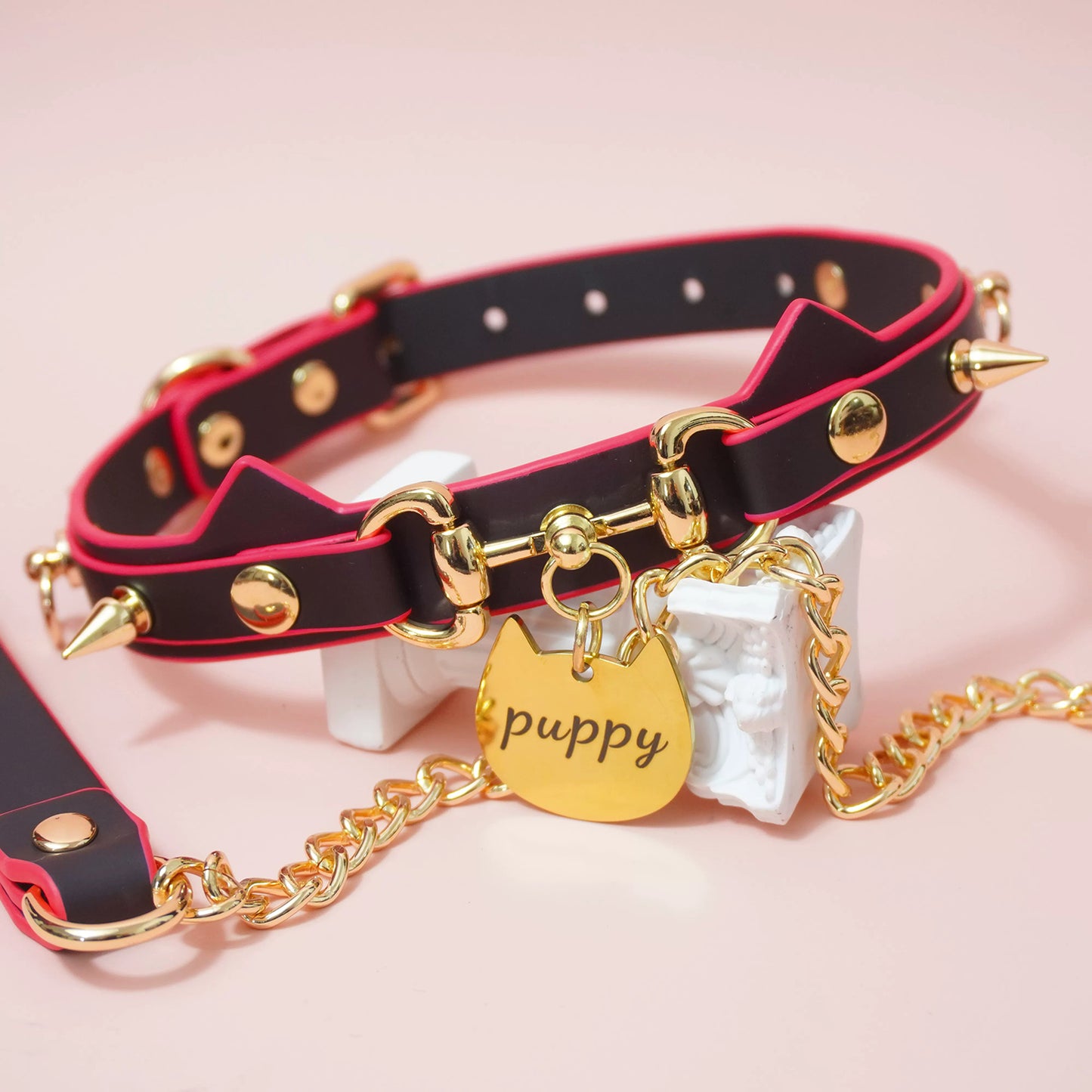 Close-up of heat-reactive color-changing black to red pet play collar featuring spiked cat ears and a gold puppy charm by Sexy Maker.