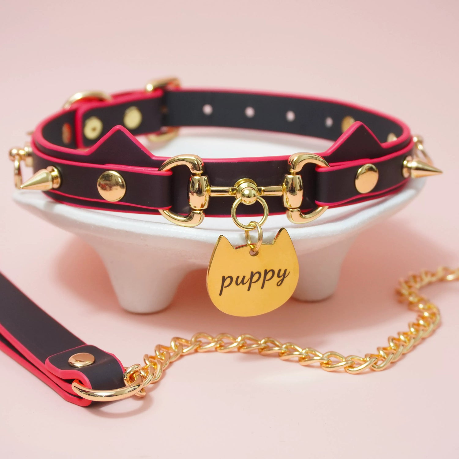 Close-up of heat-reactive color-changing black to red pet play collar featuring spiked cat ears and a gold puppy charm by Sexy Maker.