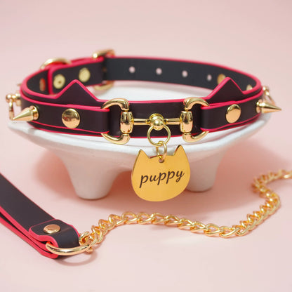Close-up of heat-reactive color-changing black to red pet play collar featuring spiked cat ears and a gold puppy charm by Sexy Maker.